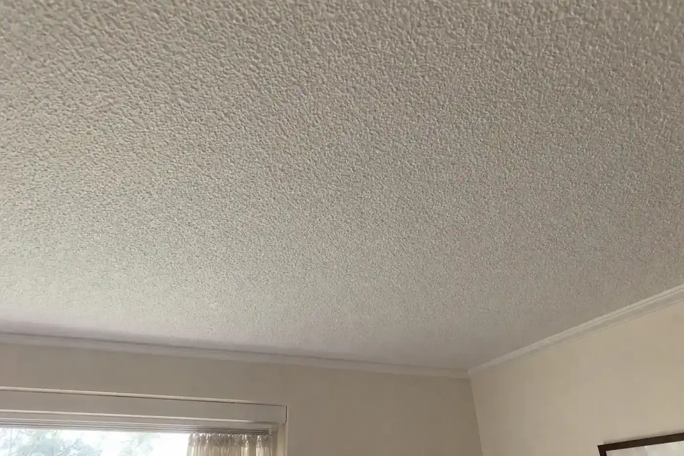 White textured stipple popcorn ceiling in an older Perth home, viewed from below in soft natural light